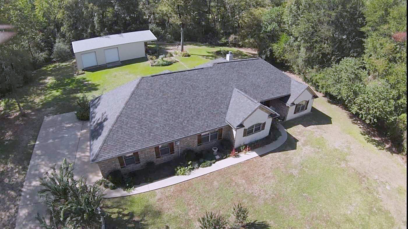 Aerial view of a single-story home roof among trees