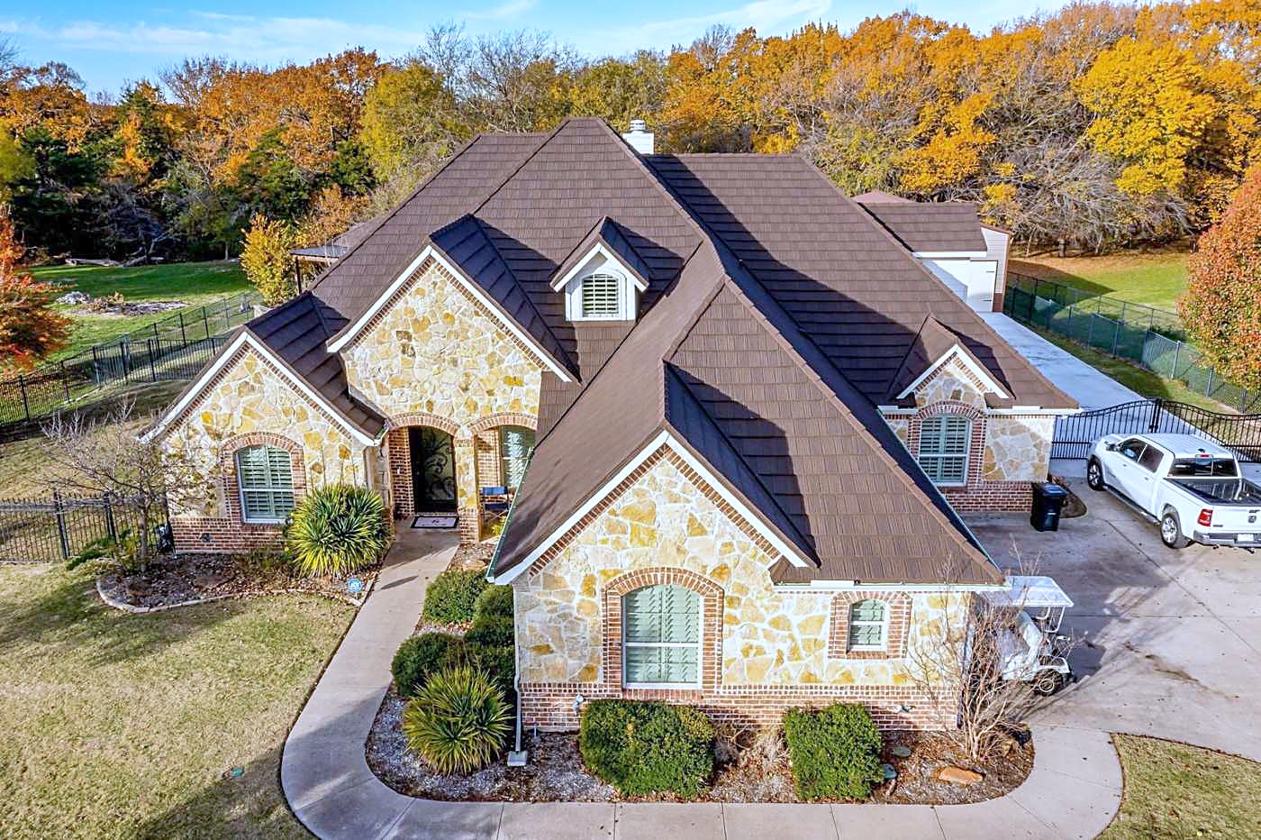Aerial view of a stone home with a stone coated steel roof